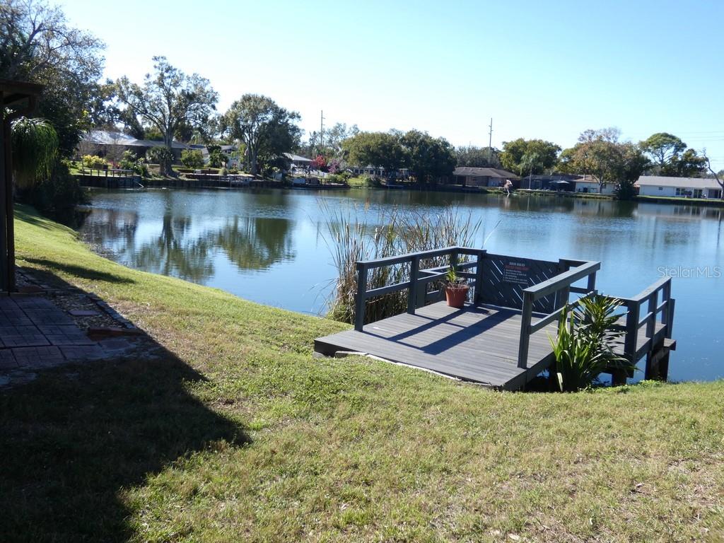 1960 Union Street, Unit 41 Clearwater, FL 33763 - Photo 36 of 45 a view of a lake with a bench and trees in the background