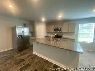 a kitchen with granite countertop a refrigerator and a sink