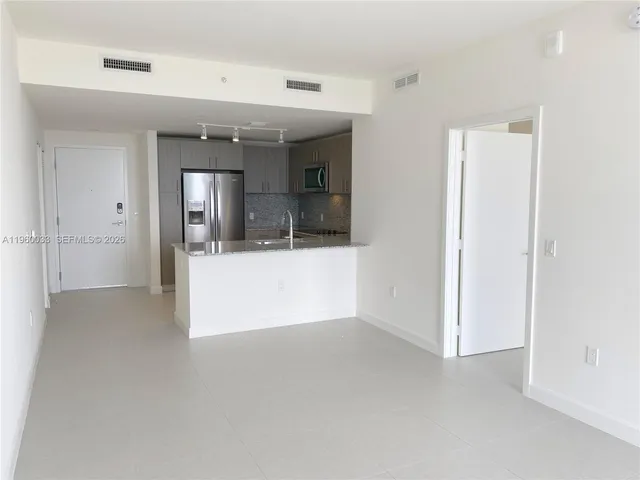 an empty room with windows and view of balcony