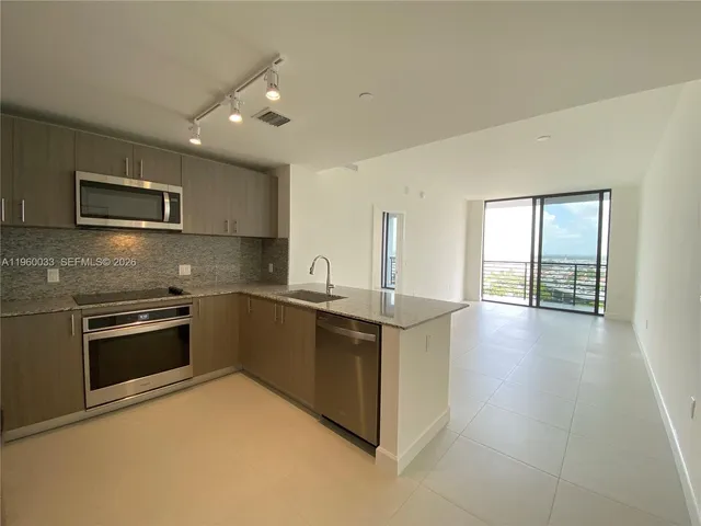 a kitchen with stainless steel appliances granite countertop a stove a refrigerator and a microwave