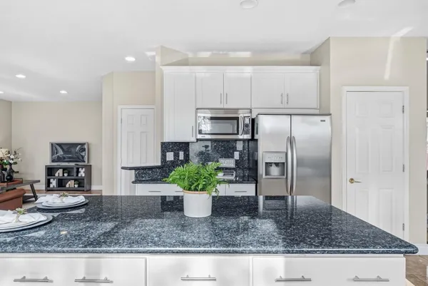 a kitchen with a refrigerator a stove and cabinets