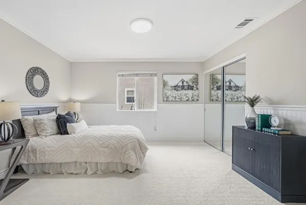 a bedroom with a bed and a large window
