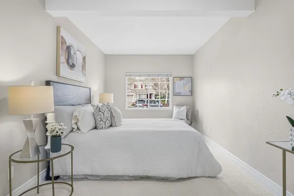 a bedroom with a large bed and a lamp with window