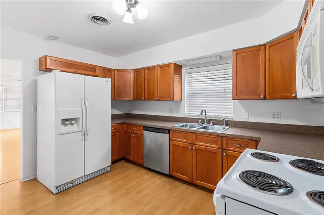 a kitchen with a sink a refrigerator and cabinets
