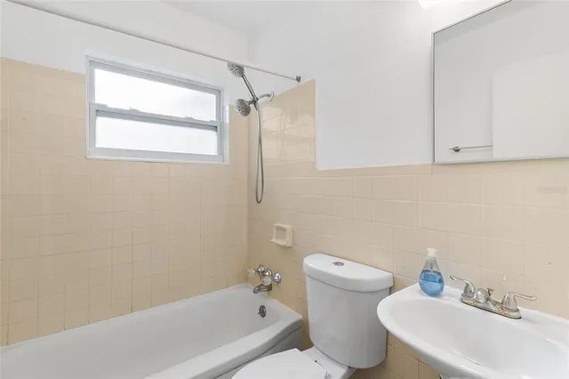 a bath room with a toilet sink and a bath tub