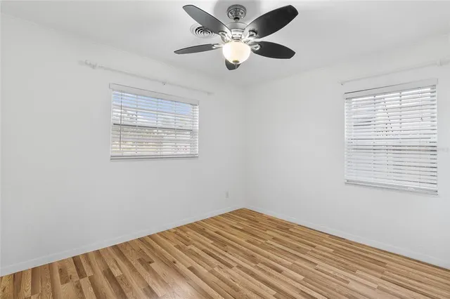a view of a room with a ceiling fan and a window