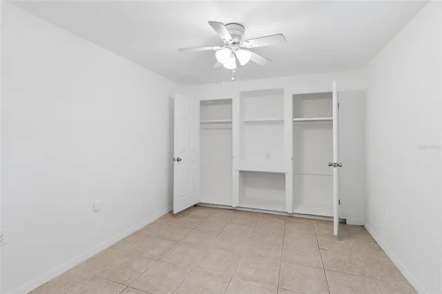 an empty room with a windows and ceiling fan