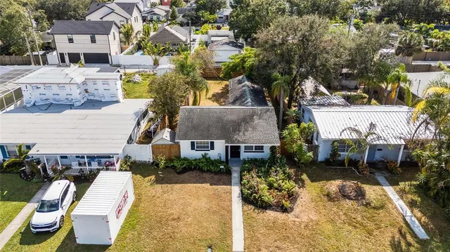 an aerial view of a house with swimming pool and large trees
