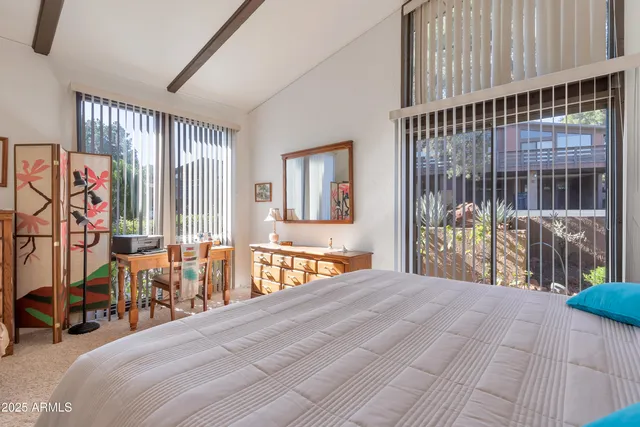 a bedroom with a large bed and a chandelier
