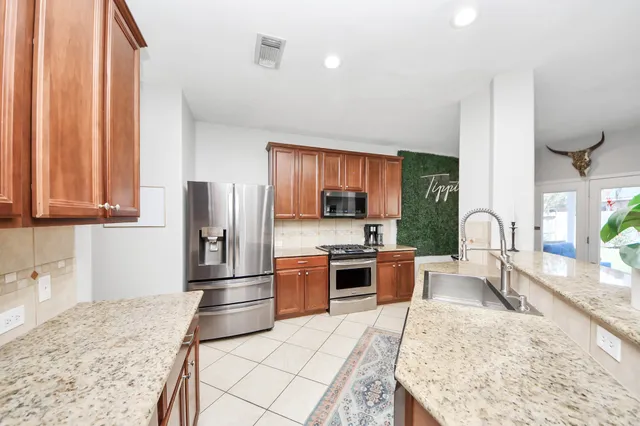 a kitchen with granite countertop a refrigerator and a sink