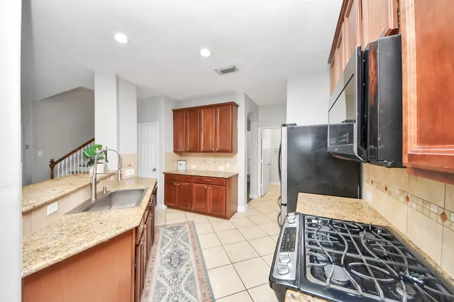 a kitchen with stainless steel appliances granite countertop a sink stove and refrigerator