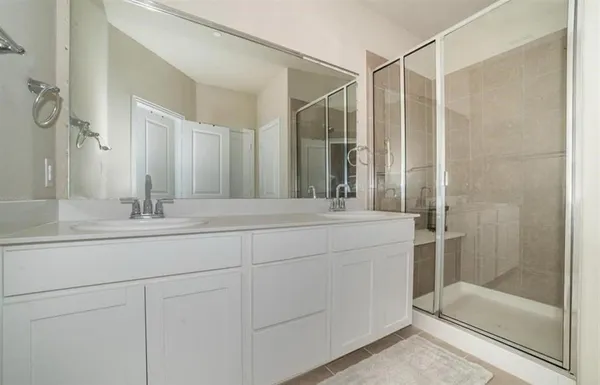 a bathroom with a shower sink and mirror