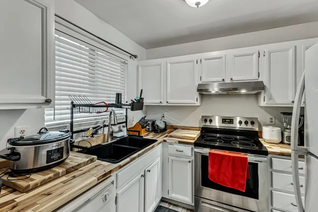 a kitchen with stainless steel appliances a stove a sink a refrigerator and cabinets