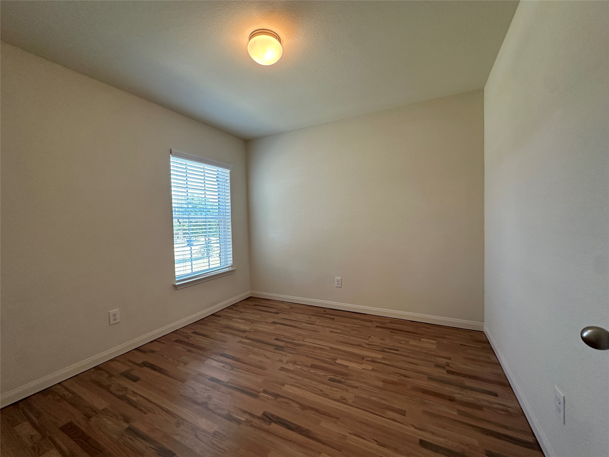 104 Millers Loop Jarrell, TX 76537 - Photo 9 of 11 This room features wood-look flooring, light-colored walls, and a window with horizontal blinds