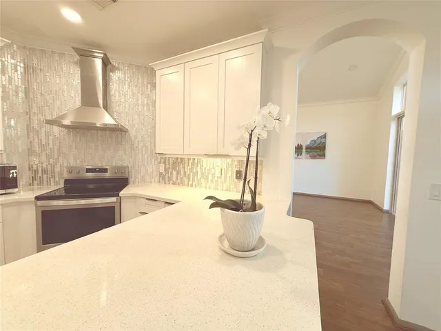 a large white kitchen with a sink and dishwasher a stove with wooden floor