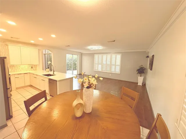 a large white kitchen with wooden floor and a sink