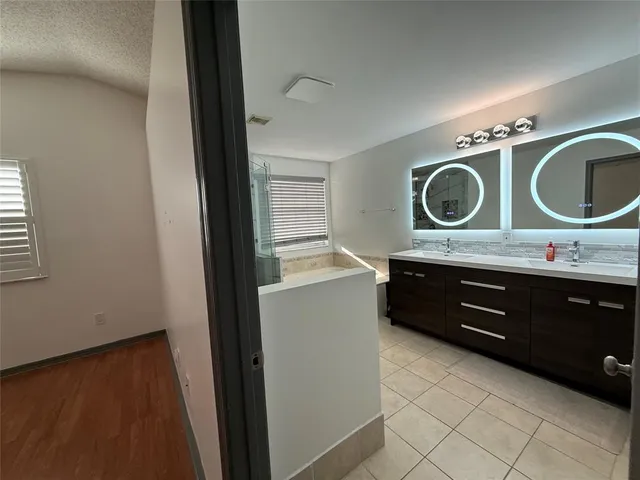a en suite bathroom with a double vanity sink and a mirror