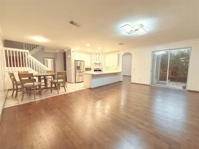 a view of a living room and kitchen with furniture wooden floor and windows