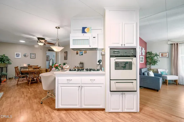 a kitchen with white cabinets and appliances