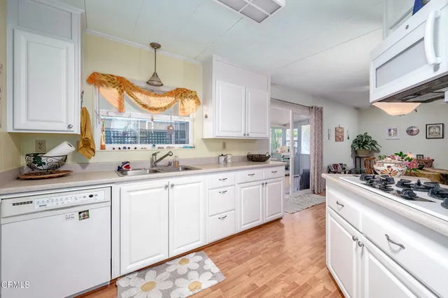 a kitchen with kitchen island granite countertop white cabinets and white appliances