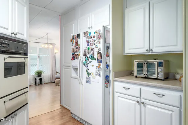 a kitchen with stainless steel appliances white cabinets and a refrigerator