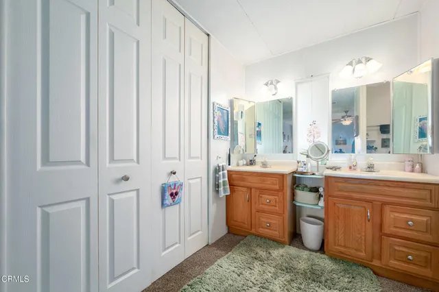 a spacious bathroom with a double vanity sink a mirror and a