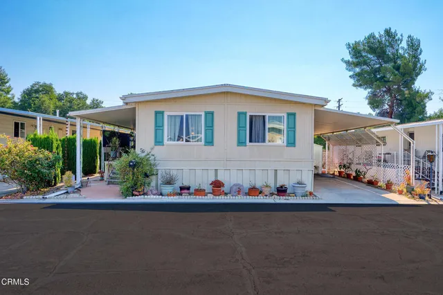 a front view of house with yard and trees in the background