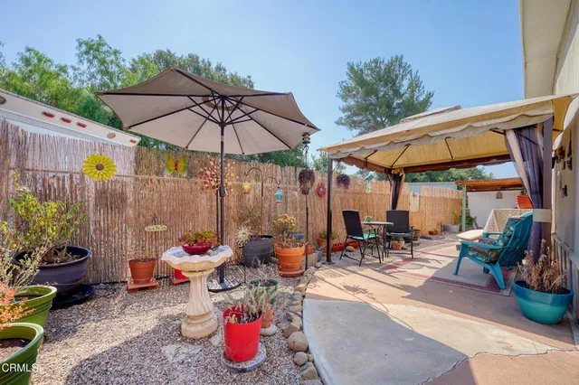 a view of a patio with table and chairs under an umbrella