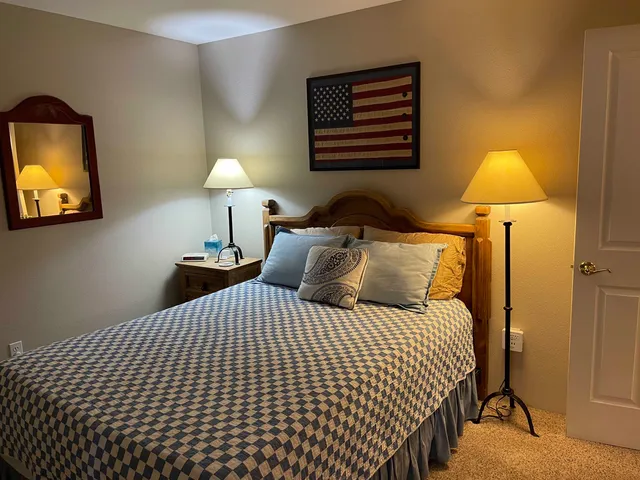 a bedroom with a bed and a lamp