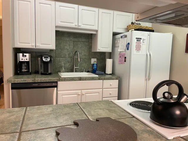 a kitchen with stainless steel appliances granite countertop a sink and a refrigerator