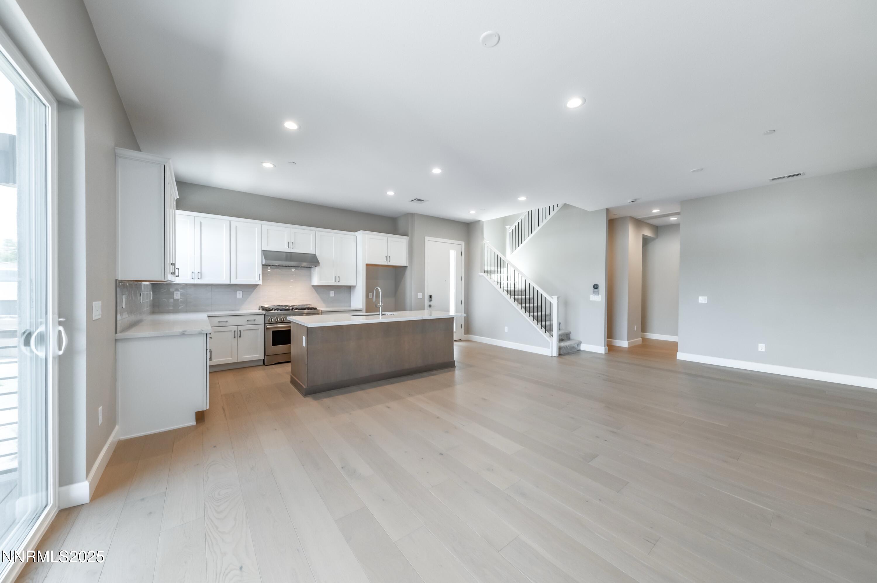 a view of kitchen with kitchen island and stainless steel appliances
