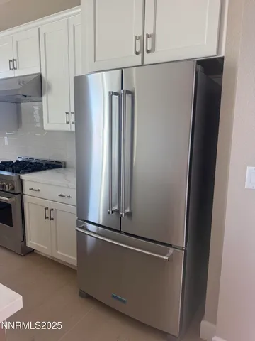 a white refrigerator freezer and a stove sitting inside of a kitchen