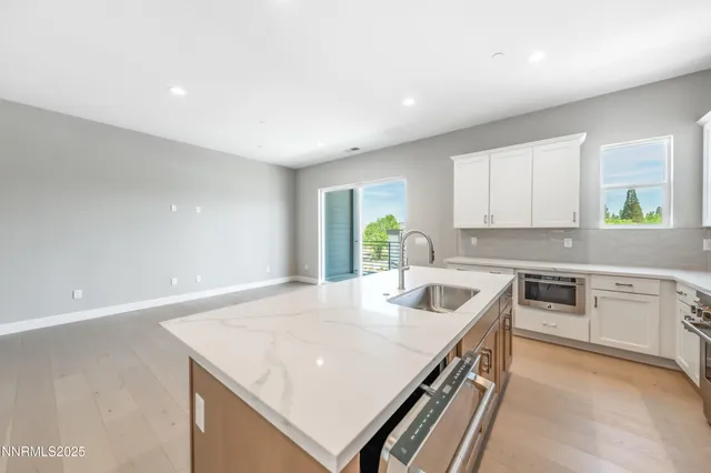 a kitchen with a sink cabinets and wooden floor