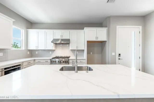 a kitchen with a stove a refrigerator a sink a counter space and cabinets