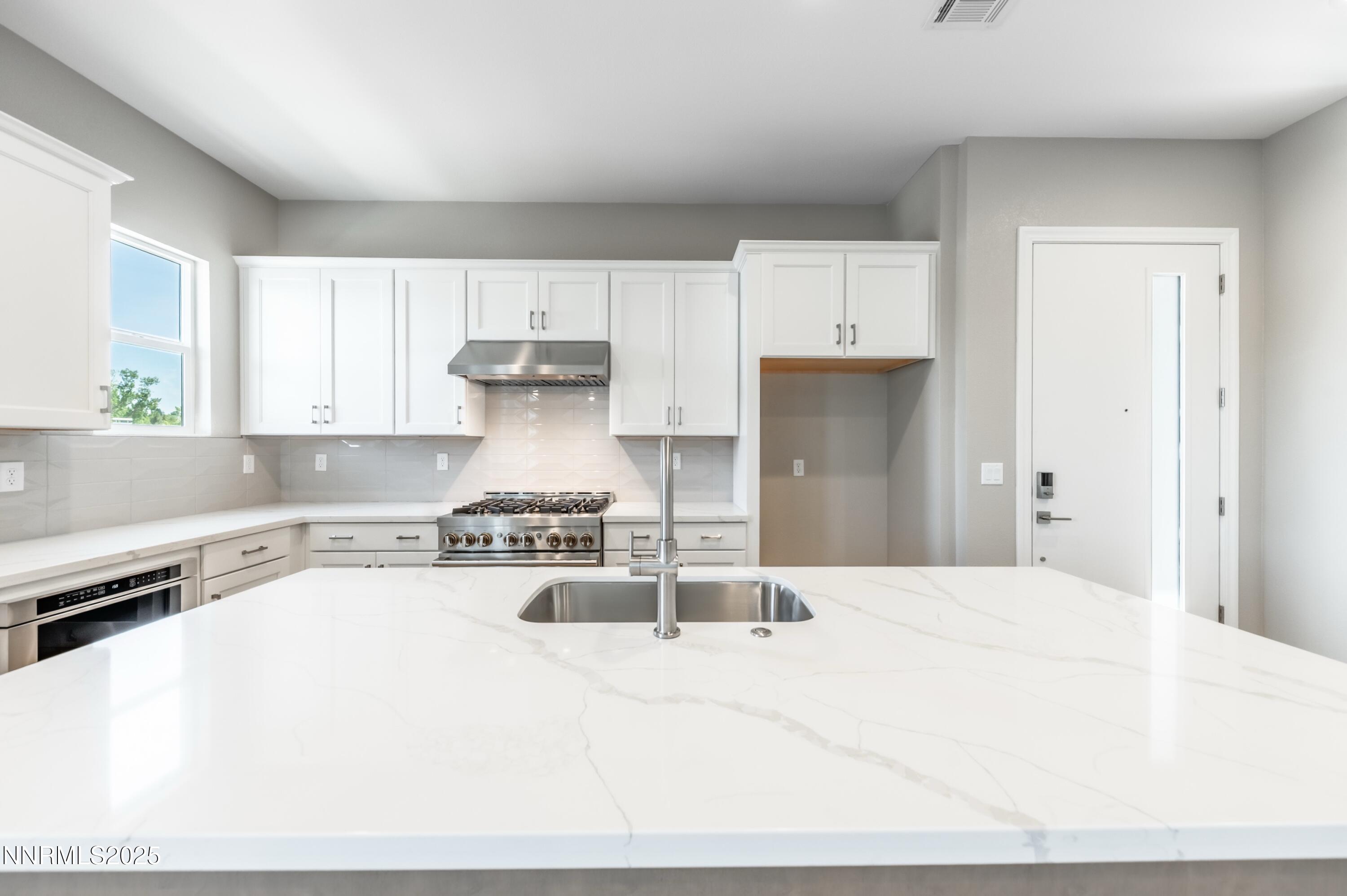 1513 Golf Club Drive Reno, NV 89519 - Photo 5 of 34 a kitchen with a stove a refrigerator a sink a counter space and cabinets