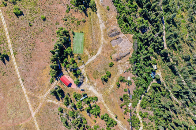 1063 West Kolob Ranch Drive Springdale, UT 84767 - Photo 7 of 61 Extensive rural property featuring a red-roofed building, a tennis court, and multiple dirt paths, surrounded by both dense and sparse tree coverage