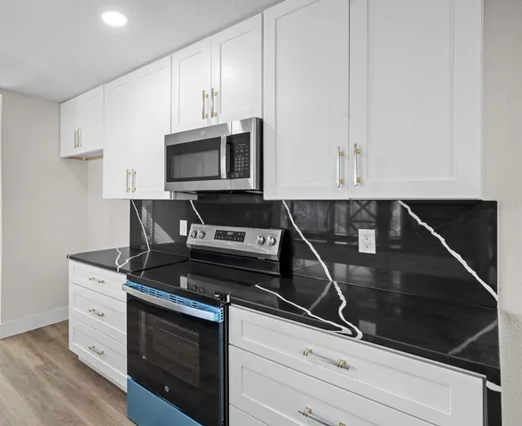a kitchen with stainless steel appliances granite countertop a sink and a stove