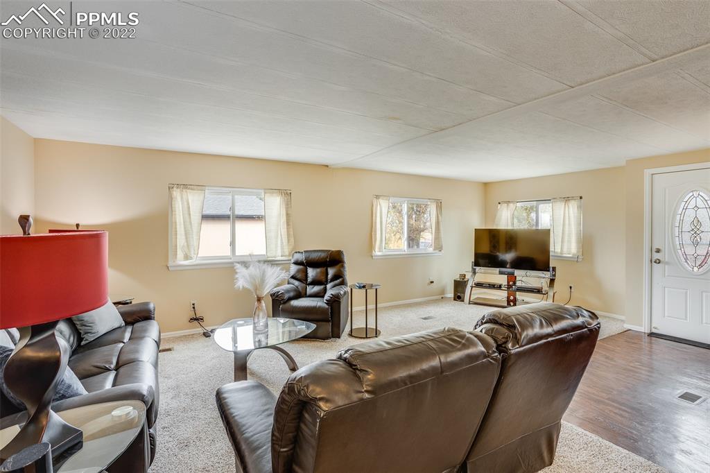 315 Cheyenne Street Calhan, CO 80808 - Photo 6 of 28 a living room with furniture a fireplace and a window