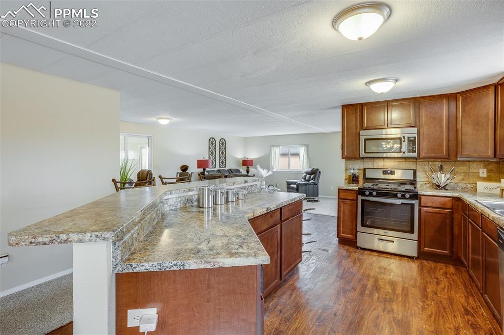315 Cheyenne Street Calhan, CO 80808 - Photo 9 of 28 a kitchen with stainless steel appliances granite countertop a stove sink and cabinets