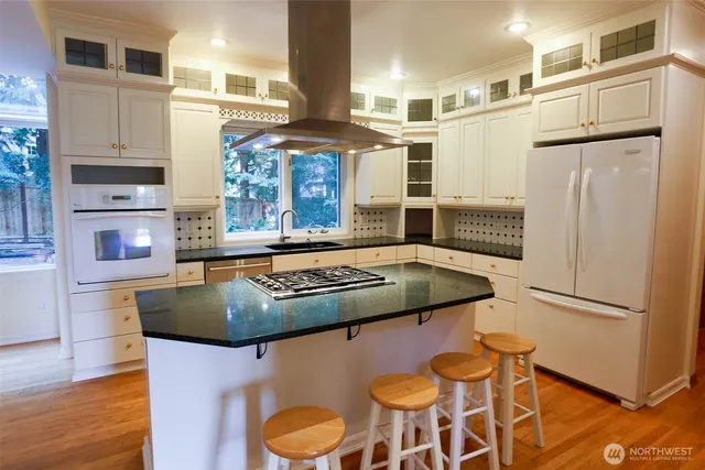 a kitchen with stainless steel appliances granite countertop a sink refrigerator and cabinets