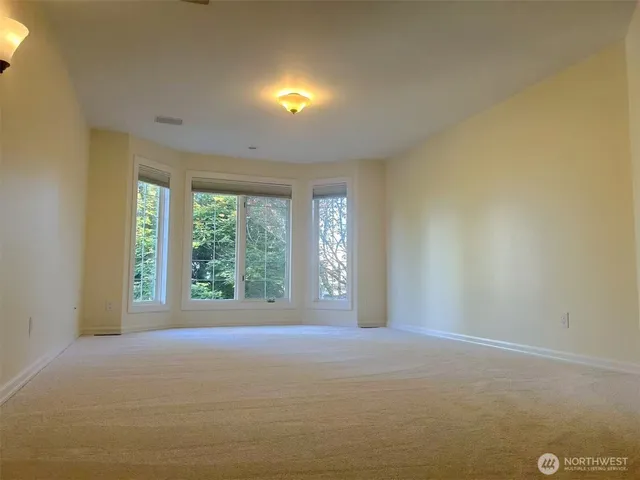 a view of a big room with windows and chandelier fan