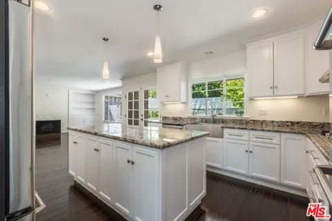 a kitchen with stainless steel appliances granite countertop a sink refrigerator and cabinets