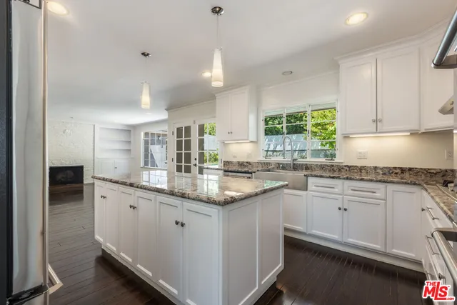 a kitchen with stainless steel appliances granite countertop a sink refrigerator and cabinets