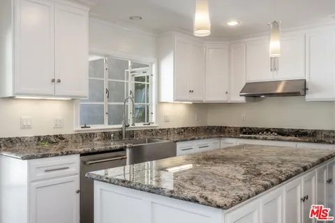 a kitchen with stainless steel appliances granite countertop a stove a sink and a refrigerator