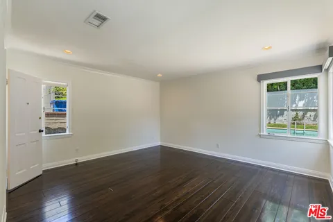 an empty room with wooden floor and window