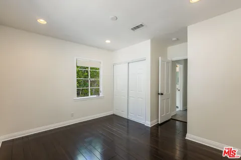 a view of a yard in front of a house with large trees
