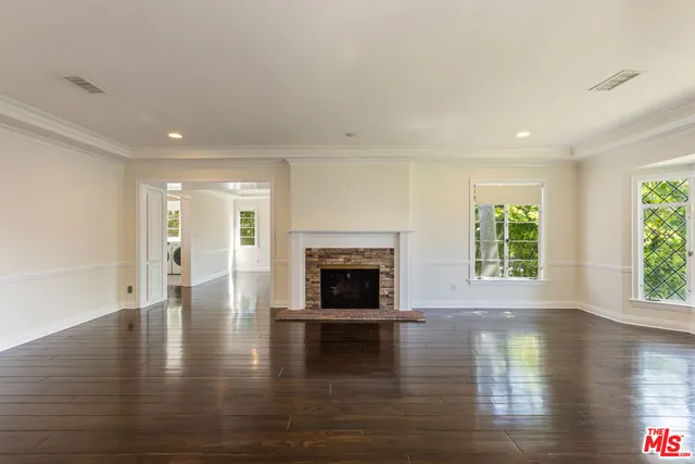 a view of empty room with wooden floor and fireplace