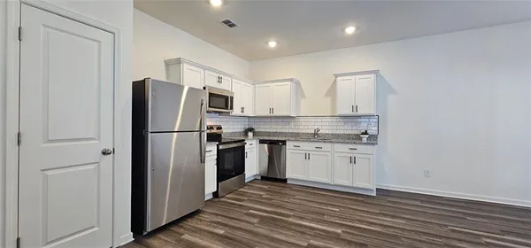 a kitchen with a refrigerator sink and cabinets