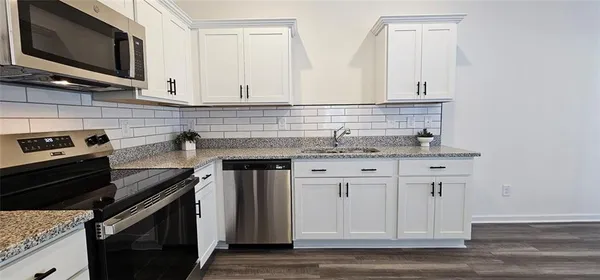 a kitchen with stainless steel appliances granite countertop a sink stove and microwave