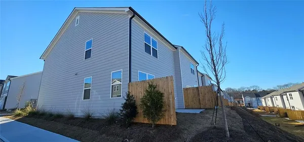 a view of a house with backyard and trees